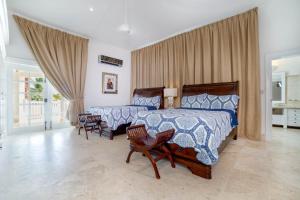 蓬塔卡纳Paradise Luxury Villa with Huge Pool and Jacuzzi的一间卧室配有两张床和两把椅子