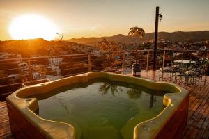 瓜纳华托Hotel 1988 Guanajuato的甲板上的热水浴池,享有日落美景