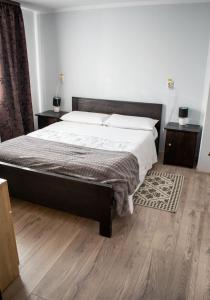 上维谢乌Casa Mocanitei的一间卧室设有一张大床,铺有木地板