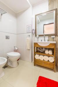 圣特雷西塔Hotel Calimera的一间带水槽、卫生间和镜子的浴室