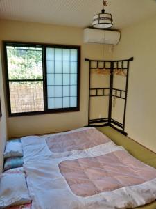 京都东山之宿 缘侧的一张大床,位于带两个窗户的房间