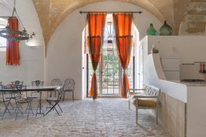 帕拉比塔Masseria Tornesella Don Giuliano的用餐室配有橙色窗帘和桌椅