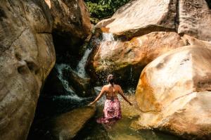 圣拉菲尔La Perla Negra - Black Pearl Eco Hostel的站在瀑布旁的水中的女人