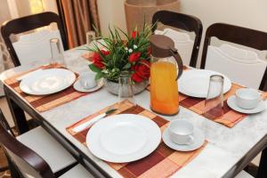 坎帕拉Eric Wilkins Apartments的一张带白板的桌子和一罐橙汁
