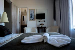 里约达欧特拉斯Atlântico Hotel的酒店客房,配有带毛巾的床