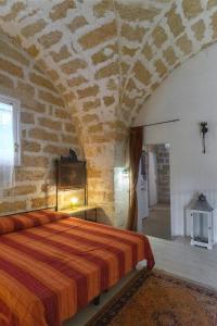 帕拉比塔Masseria Tornesella Don Giuliano的卧室配有一张石墙床