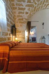 帕拉比塔Masseria Tornesella Don Giuliano的卧室配有一张石墙内的大床