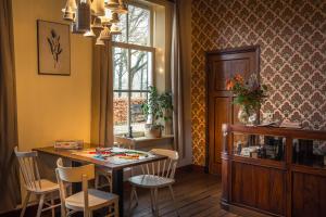LuttenbergHet Spijkerhuys的一间带桌椅和窗户的用餐室