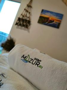 MałkinieRelax Houses - Domy Mazur的床上的毛巾,上面有标志