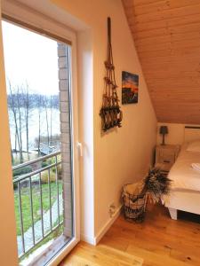 MałkinieRelax Houses - Domy Mazur的一间带窗户和床的卧室以及一个阳台