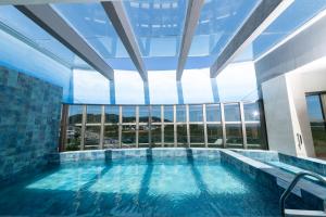 弗洛里亚诺波利斯Intercity Portofino Florianópolis的一座大型游泳池,位于一座带大窗户的建筑内