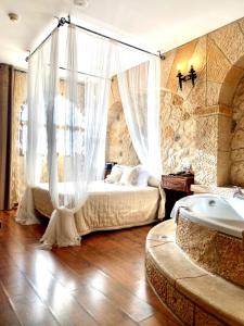 佩多拉卡斯蒂略博纳维亚酒店的一间卧室配有一张带窗帘的床和浴缸