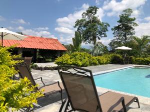 拉特瓦伊达Finca Hotel Brasilia的一个带两把椅子的庭院和一个游泳池