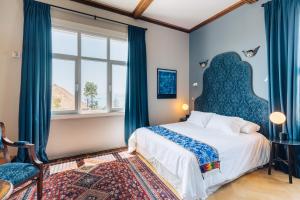 瓦尔帕莱索Casablu Hotel的一间卧室配有一张带蓝色窗帘的大床