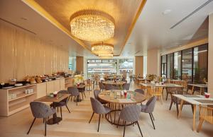 芭堤雅市中心芭堤雅海景酒店 - SHA Extra Plus的一间带桌椅和吊灯的餐厅