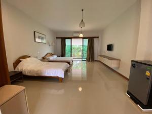 Damnoen Saduak丹农卡尔度假村的一间卧室配有两张床和电视。