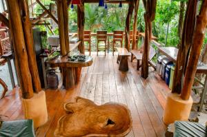 萨玛拉Tico Adventure Lodge的客房铺有木地板,配有桌椅。