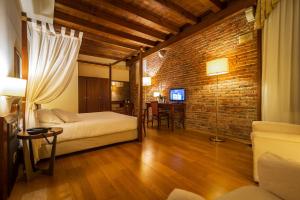 威尼托自由堡亚拉托瑞酒店的一间设有两张床和砖墙的房间