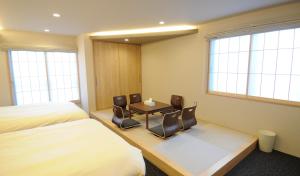 京都HIZ HOTEL Kyoto-Nijo Castle的酒店客房带一张床、一张桌子和椅子