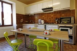 特雷尼La Garçonnière的厨房配有木桌和绿色椅子