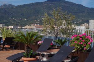 阿雅克修斯邦塔迪玛尔酒店的阳台配有桌子和盆栽植物,享有山景