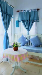 华欣普拉塔纳花园海滩度假酒店的一间卧室配有两张带蓝色窗帘的床和一张桌子