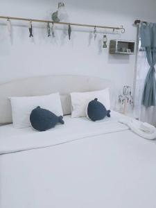 华欣普拉塔纳花园海滩度假酒店的白色床上的2个枕头