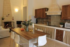 圣维托诺曼Masseria Zambardo的厨房配有木桌和白色椅子