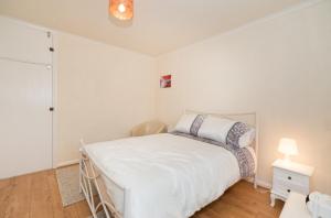 伦敦TDM Bachelot Lettings Ltd的白色卧室配有床和灯