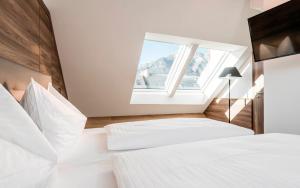 因斯布鲁克扎克酒店的一间卧室设有两张白色的床和窗户