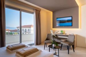 切齐纳码头Palace Lido Hotel & Suites的客房设有桌椅和大窗户。