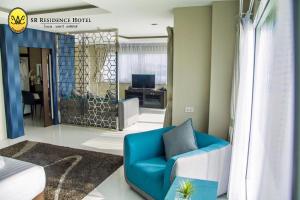 碧差汶SR酒店的客厅配有蓝色椅子和书桌