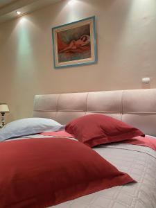 雅典彭德里奢华公寓的一张带红色和白色枕头的床