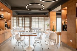 切齐纳码头Palace Lido Hotel & Suites的一间带桌子和白色椅子的用餐室