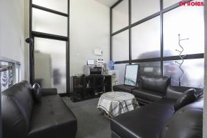 仁川市Hotel Hue Loft的客厅配有黑色皮革家具和窗户。