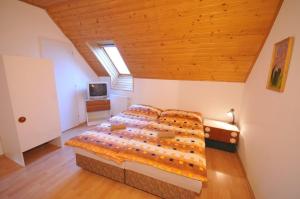 新里斯拉Penzión Belvia的一间卧室设有一张带木制天花板的大床