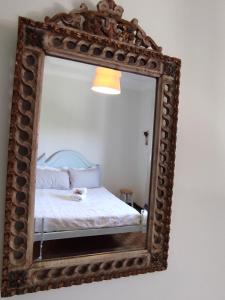 圣托·蒂尔索Casa das Flores的镜子和床上的床铺
