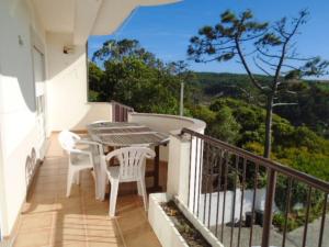 帕塔亚什2 bedrooms villa at Pataias 700 m away from the beach with sea view private pool and enclosed garden的设有一个配有桌椅并享有美景的阳台。