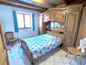 SoultzerenAppartement de 2 chambres avec jardin amenage et wifi a Soultzeren a 3 km des pistes的一间小卧室,配有一张床和一把椅子