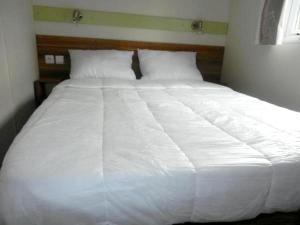 特罗格Bungalow de 3 chambres avec piscine partagee et terrasse amenagee a Trogues的卧室内的一张大白色床,带有窗户