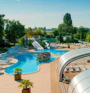 特罗格Bungalow de 3 chambres avec piscine partagee et terrasse amenagee a Trogues的一个带滑梯的度假村内的大型游泳池