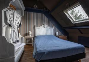 德科克斯多普Smederij Texel的一间卧室设有蓝色的床和窗户。