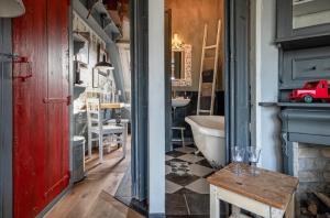 德科克斯多普Smederij Texel的一间带红色门、桌子和浴缸的浴室