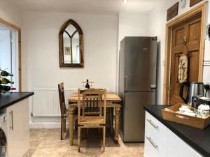 杜伦Remarkable 3-Bed House in Durham的厨房配有桌子和不锈钢冰箱。