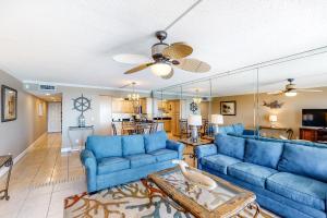 沃尔顿堡滩Island Echos 7th Floor Condos的客厅配有蓝色的沙发和吊扇