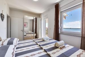 普利拉卡Beachfront villas with hot tubs Sun Garden的卧室设有两张床和大窗户