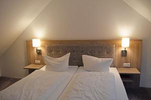 维林根猎人之家公寓式酒店的一间卧室配有两张带白色床单和枕头的床。