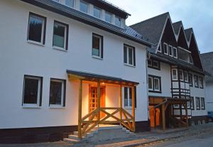 维林根猎人之家公寓式酒店的白色的房子,设有开放式门和木门廊
