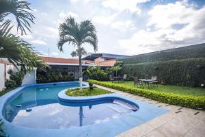 阿拉胡埃拉贝尔乐机场酒店的棕榈树庭院中的游泳池