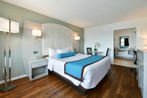 弗里波特自由港滨海酒店 的一间卧室配有一张带蓝白色床单的大床